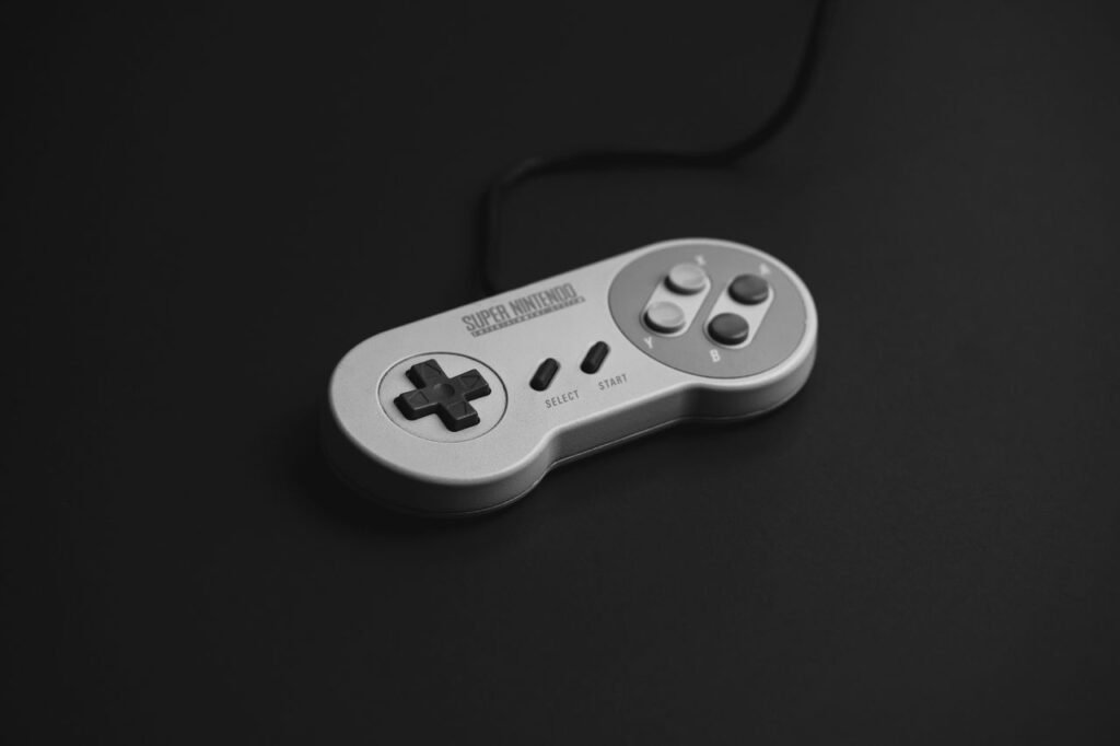pexels-photo-9201281-9201281 Close-up of a vintage Super Nintendo controller on a black background.